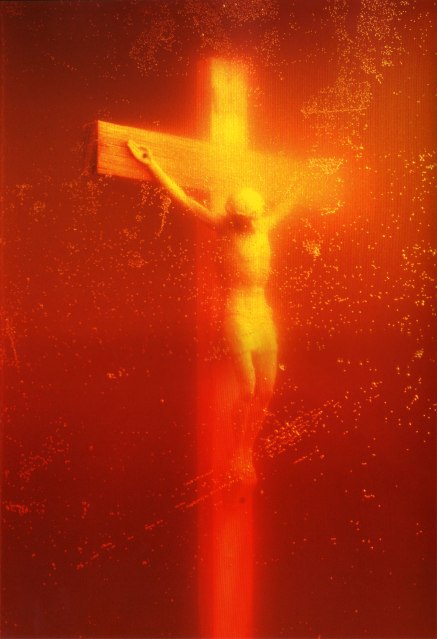 A crucifix with Christ on the cross in a golden glow from the urine he's submerged in